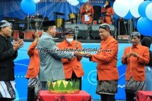 Foto penyerahan potongan tumpeng dari Kepala SMKN 1 Pati Drs Wartono kepada Waka Kesiswaan Nur Wahyudi,S.Pd sebagai Ketua Panitia