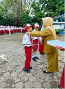 Foto pengalungan medali oleh Kepala SDN Pati Lor 04 Pati kepada siswa pencak silat