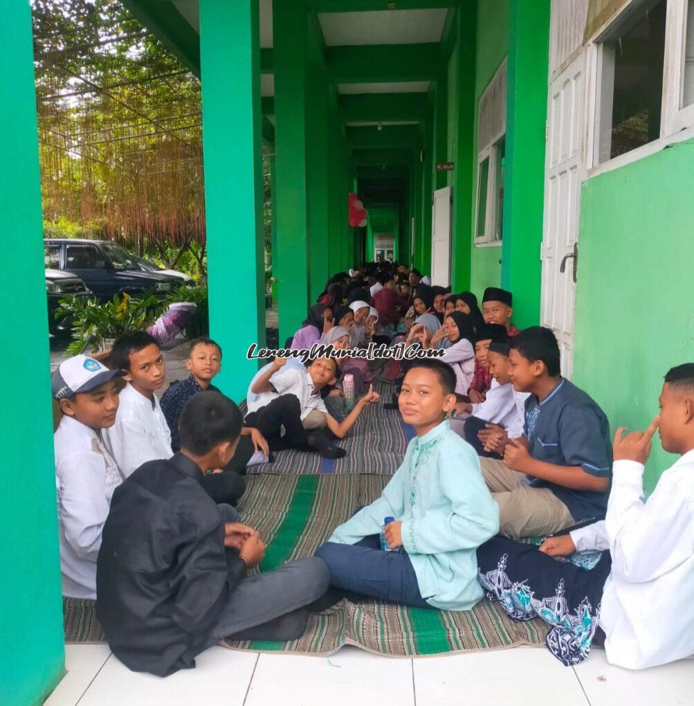 Foto siswa duduk dengan tertib, teratur dan ceria di teras kelas