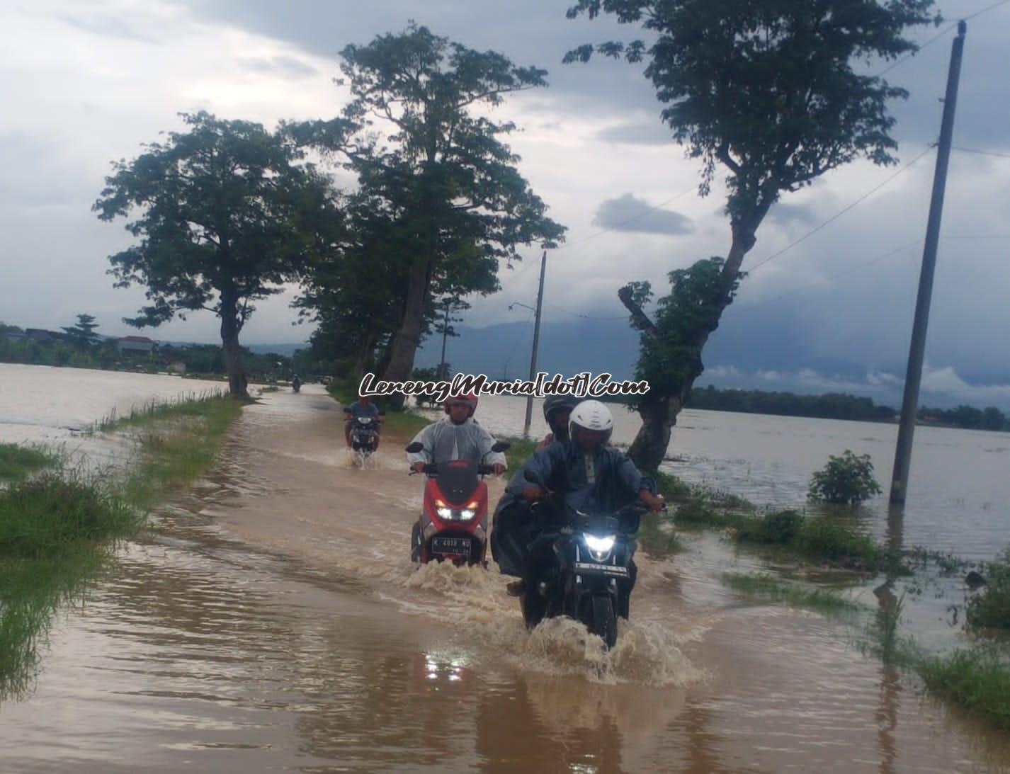 Foto pengendara sepeda motor dengan susah payah melewati genangan air