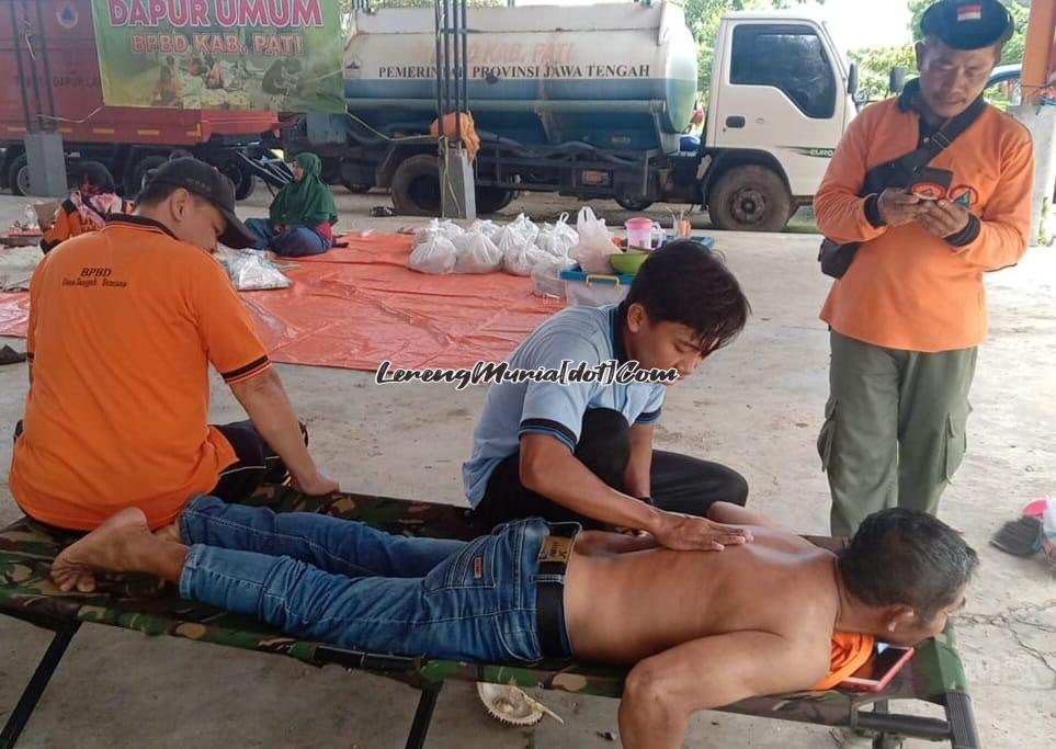 Foto Muhammad Lintang sedang memijat salah seorang relawan BPBD