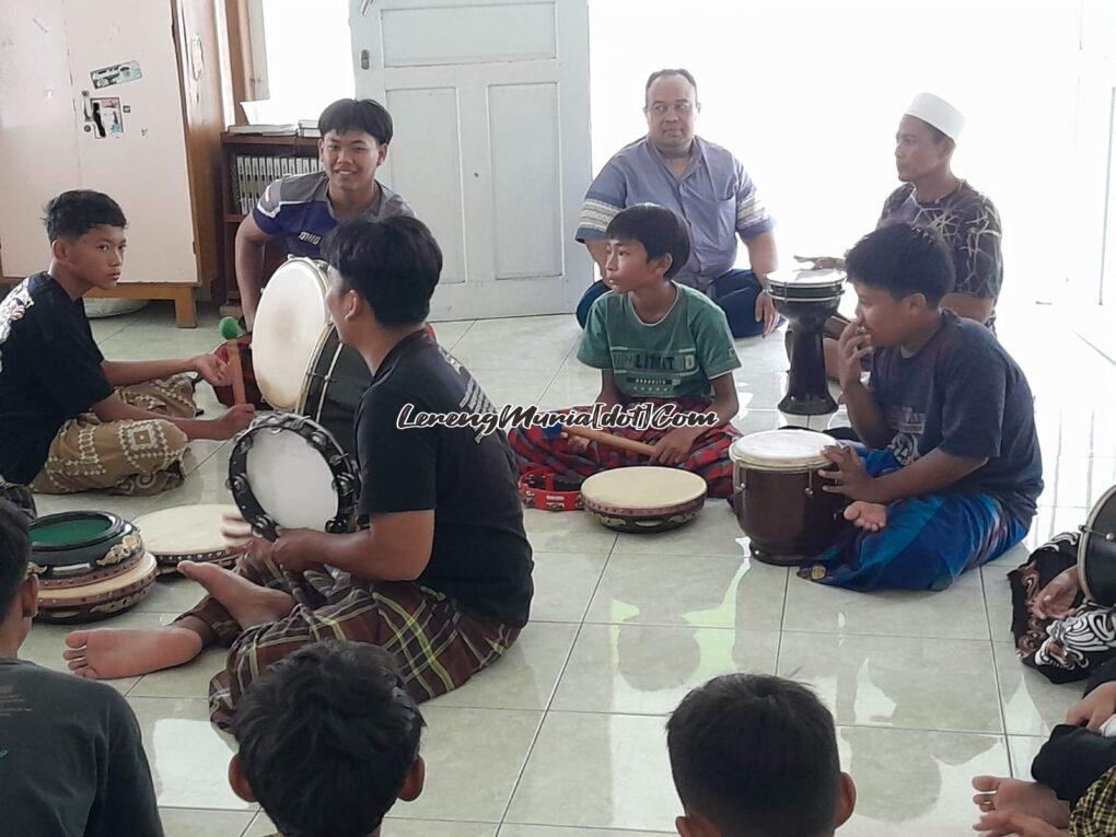 Foto pelatih sedang mengajarkan alat musik terbang/genjring