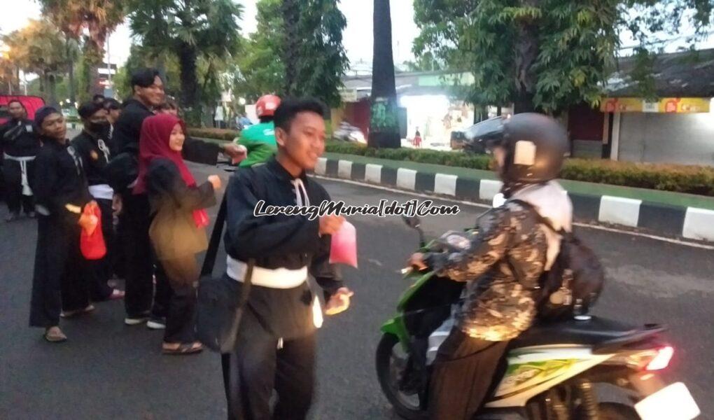 Foto anggota SH Terate sedang membagi takjil kepada pengguna jalan