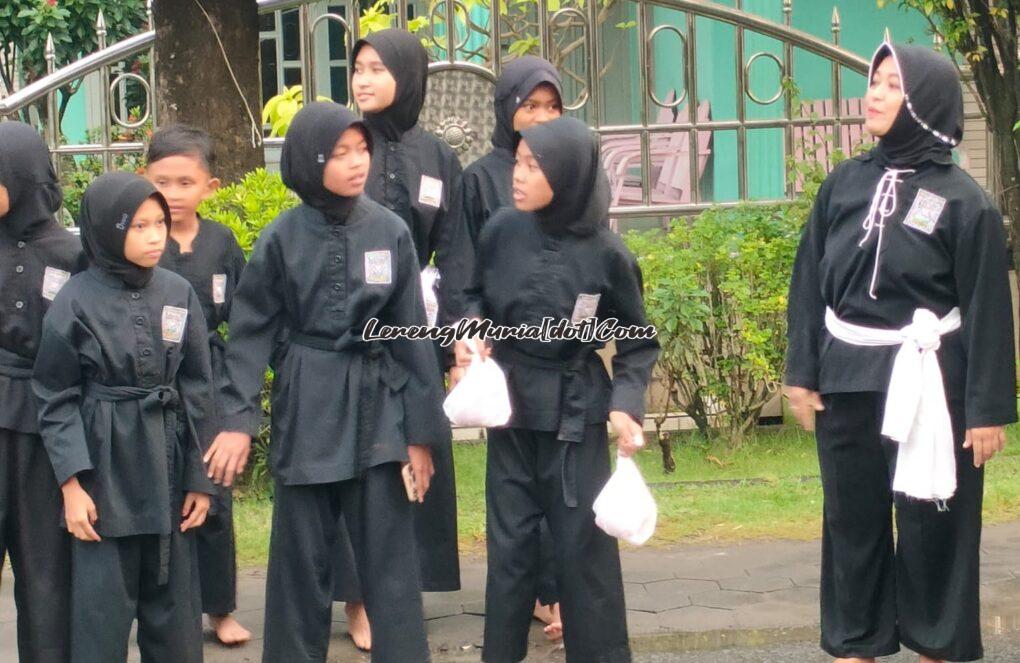 Foto Rini Setiowati (paling kanan) mendampingi siswanya membagikan takjil