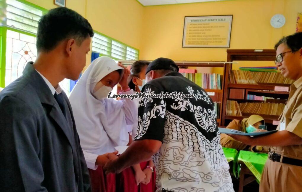 Foto Pengurus PGRI Cabang Kecamatan Pati menyalami siswa yang menerima santunan