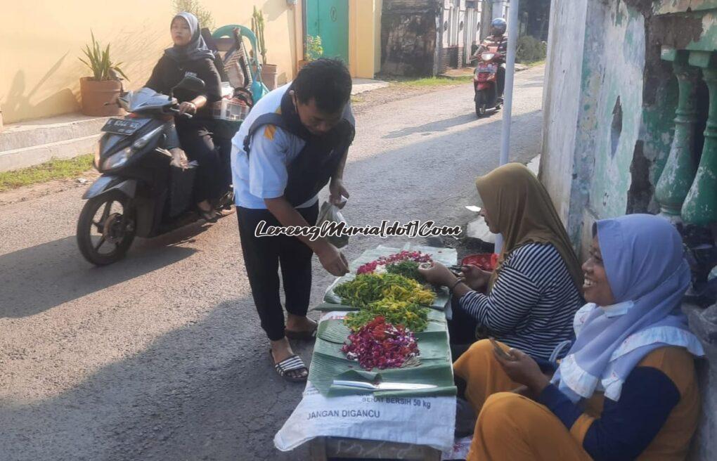 Foto Bu Ani (paling kanan) pedagang bunga tabur dadakan depan Pasar Puri Baru  sedang melayani pembeli