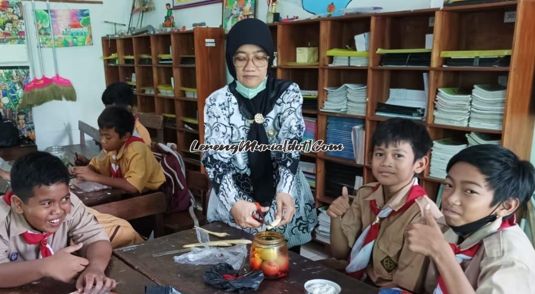 Foto Guru  Klara Rosita Musiana, S.Pd. sedang membimbing siswa membuat telur asin