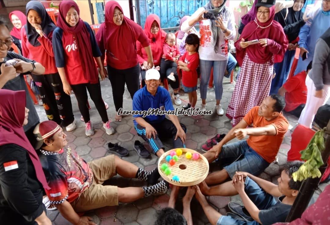 Foto lomba memasukkan bola ke dalam lubang tampah yang diikuti oleh  bapak-bapak penuh dengan kelucuan