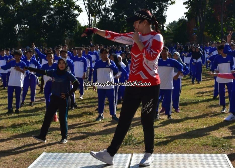 Foto instruktur senam Jenny sedang memandu  guru/karyawan dan siswa dalam acara Jumat Sehat