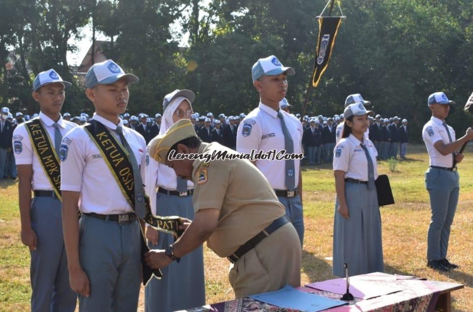 Foto pemakaian slempang Ketua OSIS SMAN 3 Pati oleh Kepala Sekolah kepada Ketua Umum OSIS yang baru