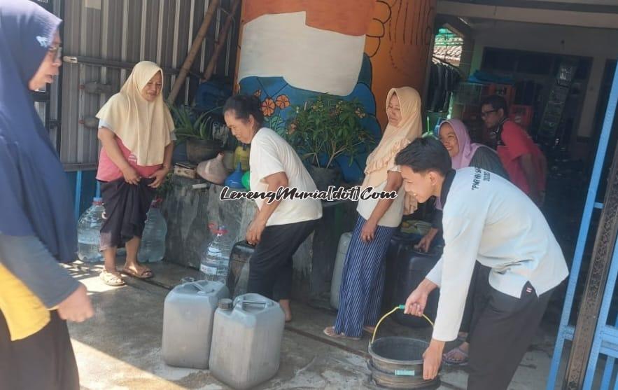 Foto warga Desa Gebang dengan rasa gembira menggunakan berbagai wadah untuk mengambil air bersih dari baksosnya PMR Wira SMAN 3 Pati