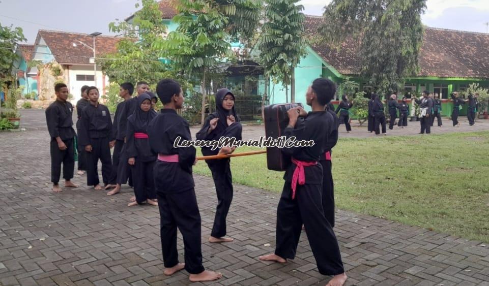 Foto atlet Sempati sedang latihan teknik tendangan A kobra dengan alat bantu tongkat dan peaching