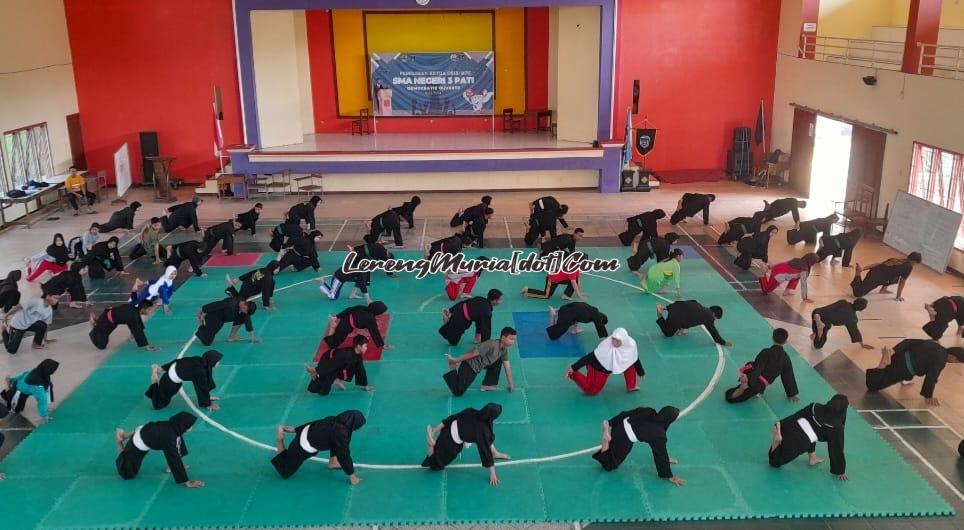 Foto pesilat SMAN 3 Pati sedang pemanasan sebelum latihan teknik di Auditorium SMAGA