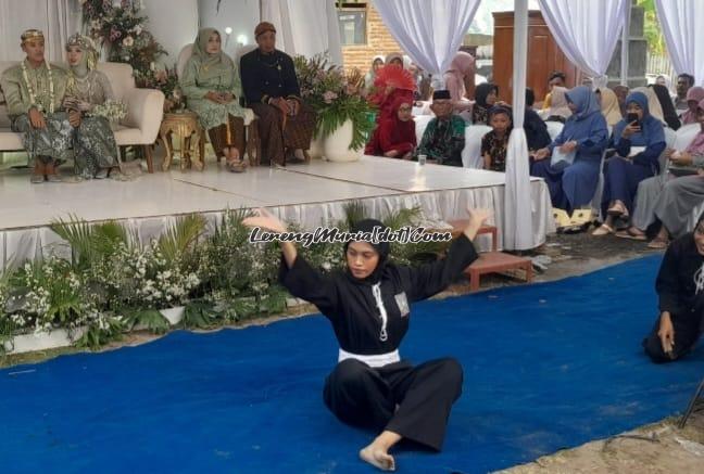 Foto Melinda Yulia Astuti sedang menampilkan jurus seni di atas karpet biru di depan mempelai berdua