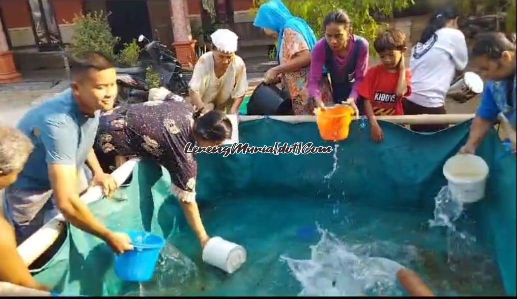 Foto warga Desa Tambahmulyo sedang mengambil air bersih di penampungan air dengan perasaan gembira