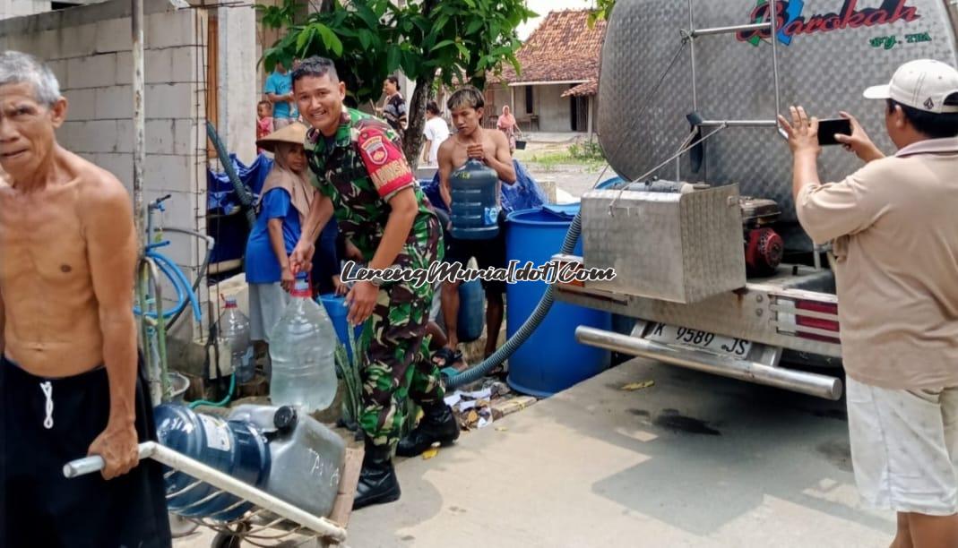 Foto warga bersama aparat Babinsa Koramil Winong memindahkan air bersih ke wadah galon bantuan dari Alumni SMAN 2 Pati Angkatan 1992