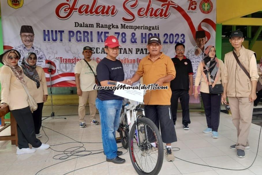 Foto Bapak Purbo (2 dari kanan depan)  menerima hadiah door prize  sepeda gunung didampingi Ketua PGRI Kabupaten Pati Winarto, S.Pd., M.Hum. (2 dari kiri depan)