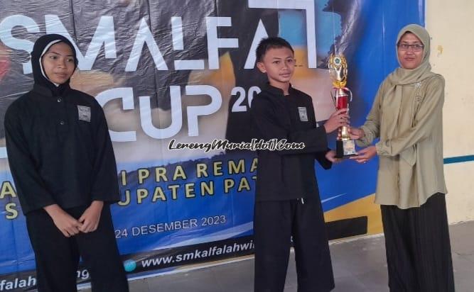 Foto penyerahan piala pesilat terbaik putra oleh Anggun Kusuma Dewi, S.Pd. Staf Kesiswaan Sekbid Ekstrakurikuler SMK Al Falah Winong (kanan) kepada Narayana Pradipta Adyatma W. (tengah) dari MTsN 1 Pati