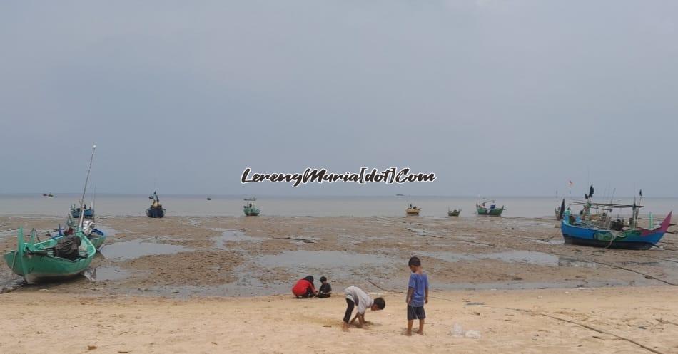 Pengunjung sedang bermain pasir putih di Pantai Wates  Rembang