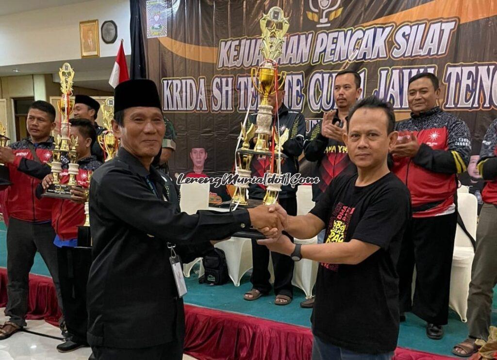 Ketua Perwapus Jateng AKBP (Purn). Sapto Yuhanis, S.H., M.H. menyerahkan piala sebagai Juara Umum I Kategori Dewasa Krida SH Terate Cup I kepada Muh. Shodiqin, S.E. selaku manager Tim SH Terate Cabang Pati