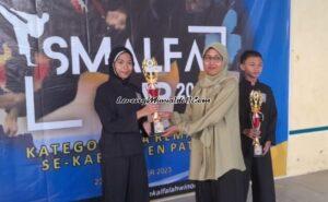 Khairaini Zalfa Nur Laili (kiri) dari SMPN 1 Juwana menerima piala sebagai pesilat putri terbaik dalam Kejuaraan SMALFA CUP 2023