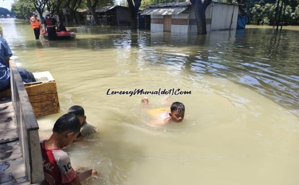 Anak-anak kecil bermain air menikmati suasana banjir