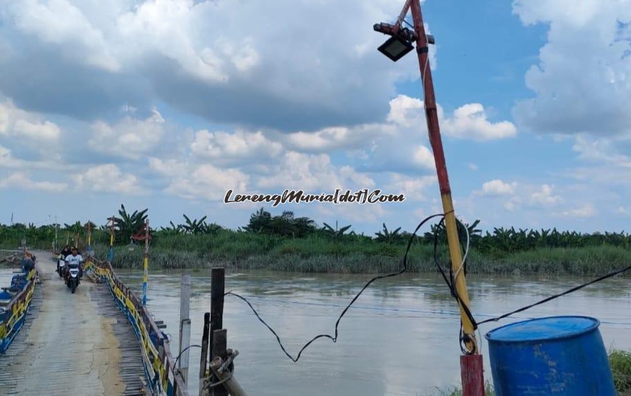 Sungai Wulan dalam keadaan meluap yang di atasnya melintang jembatan apung