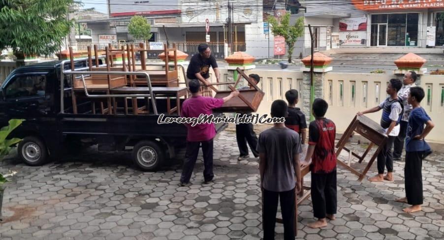 Warga bergotong royong mengangkat meja ke atas mobil untuk kepentingan TPS 17