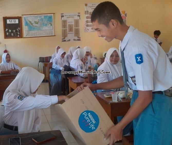 Siswa memberikan sumbangan suka rela yang dimasukkan ke dalam kardus