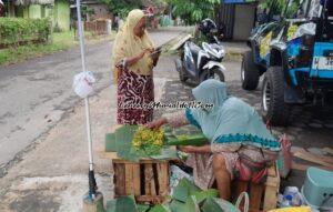 Suparmi, penjual bunga tabur dadakan di sekitar Pasar Puri Baru sedang melayani pembeli