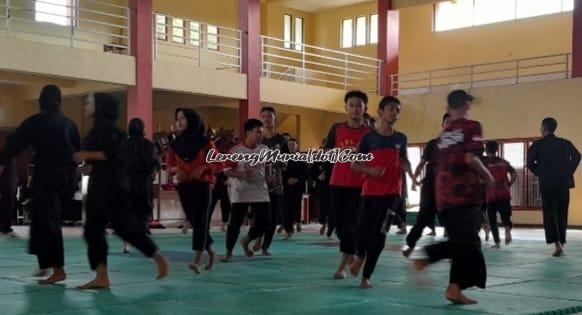 Atlet pencak silat sedang pemanasan di atas matras dengan penuh semangat walaupun sedang berpuasa