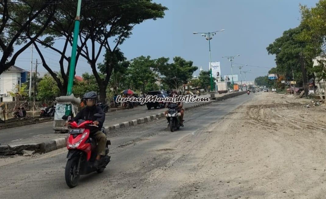 Para pengendara sepeda motor sedang melewati lumpur bekas banjir di jalan raya Pantura Karanganyar Demak