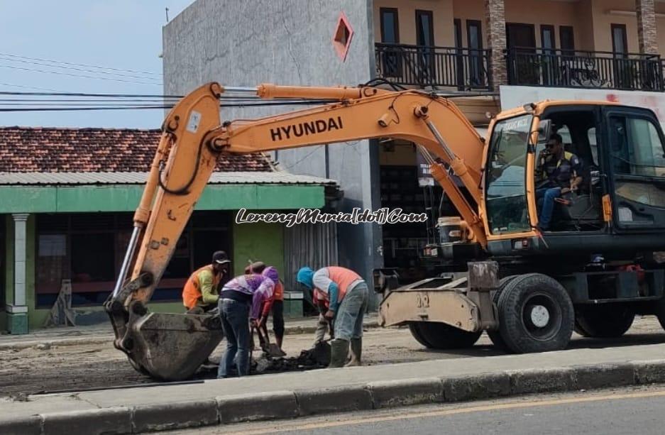 Alat berat dikerahkan untuk mengeruk dan membersihkan  lumpur di jalan raya