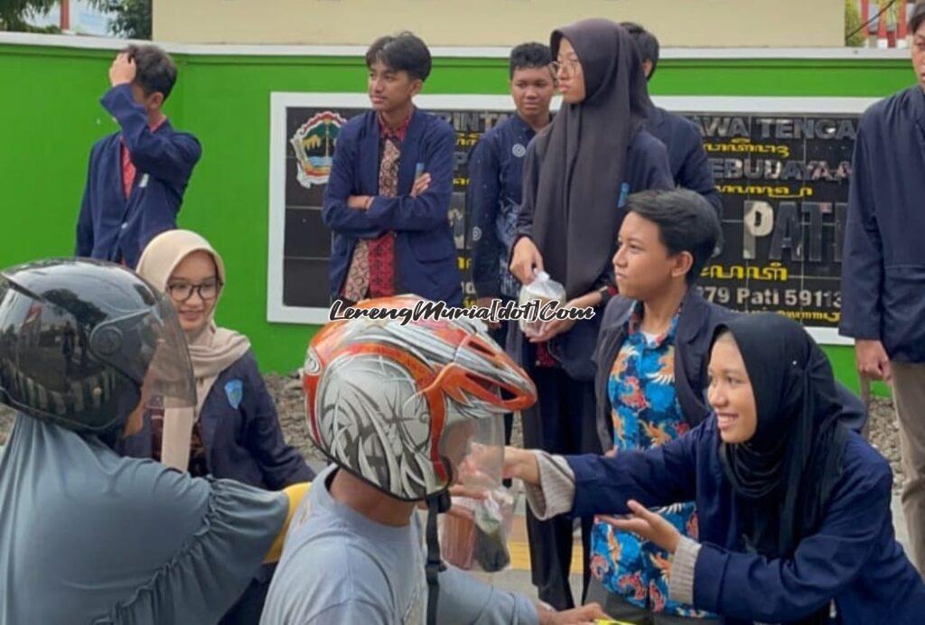 Pengurus OSIS/MPK SMAN 3 Pati sedang membagi takjil di depan sekolahnya dalam rangka memupuk rasa kepedulian