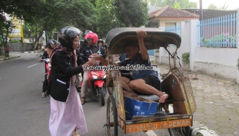 Anggota Rohis Al Falah SMAN 3 Pati menyerahkan takjil kepada tukang becak