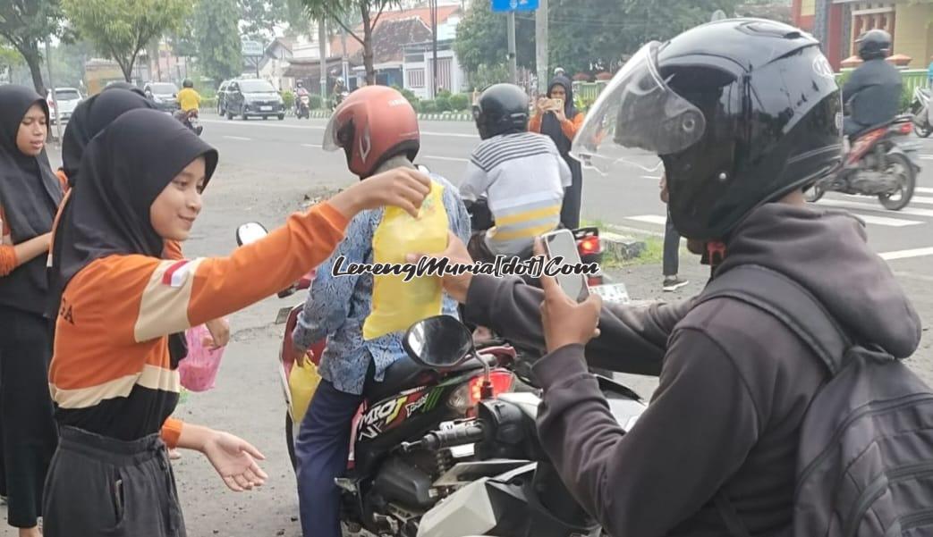 Dengan senyum ramahnya anggota Koppasga membagi takjil kepada pengendara sepeda motor di jalur lambat depan SMAN 3 Pati