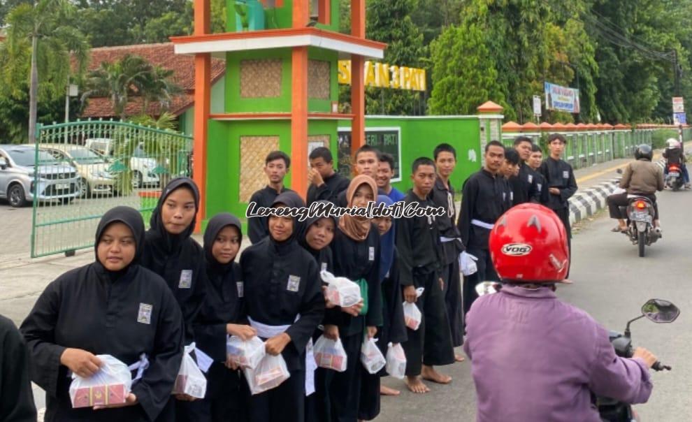 Dengan senyum ramahnya anggota SH Terate Komisariat SMAN 3 Pati memberikan takjil kepada para pengguna jalan