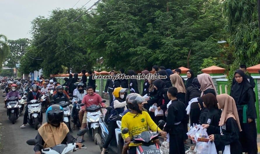 Dengan senyum ramahnya anggota SH Terate Komisariat SMAN 3 Pati memberikan takjil kepada para pengguna jalan