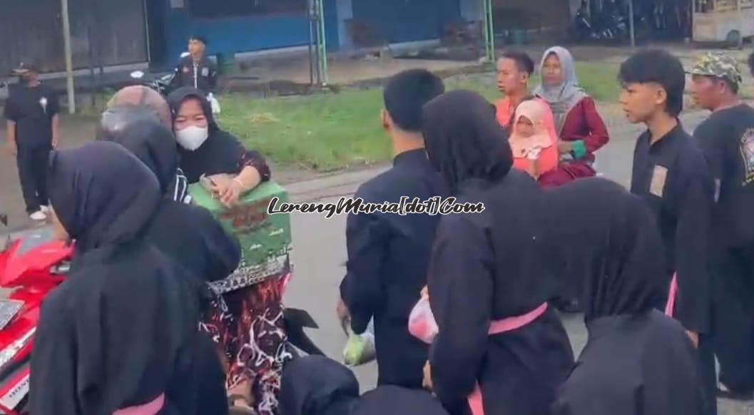 Anggota SH Terate Ranting Tayu sedang memberikan takjil kepada pengguna jalan