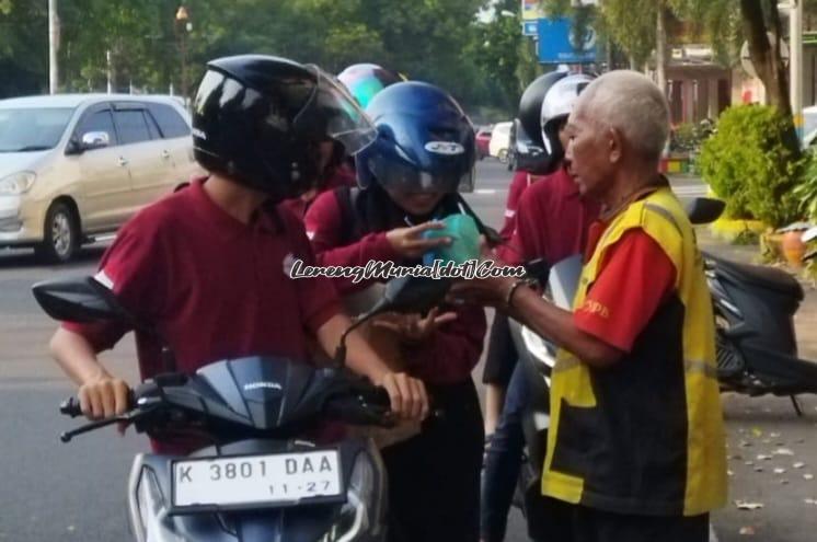 Anggota Kobra sedang membagikan takjil kepada tukang parkir yang dijumpai di lokasi pembagian