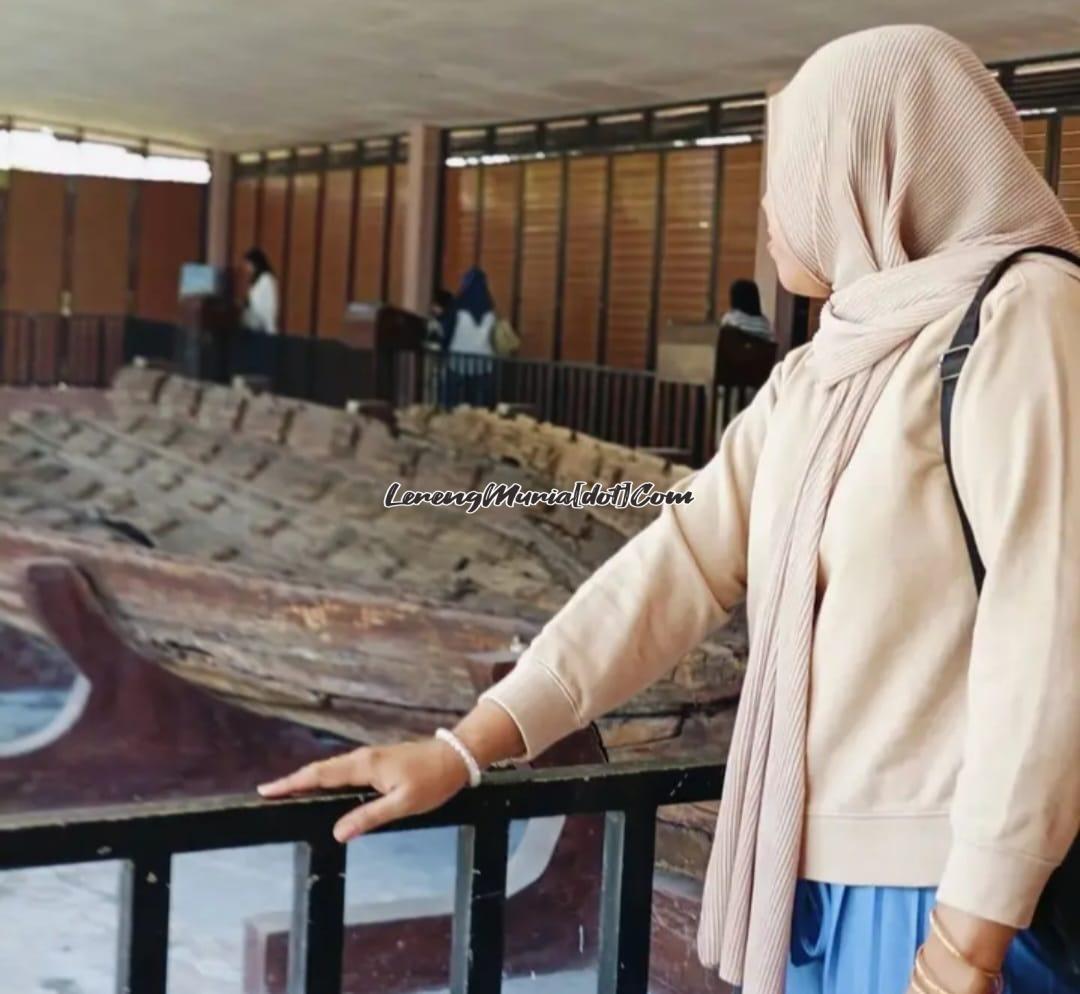 Liyanti, salah satu warga Perum Rendole Indah Pati memperhatikan perahu kuno di Situs Perahu Rembang Desa Punjulharjo Kecamatan Rembang