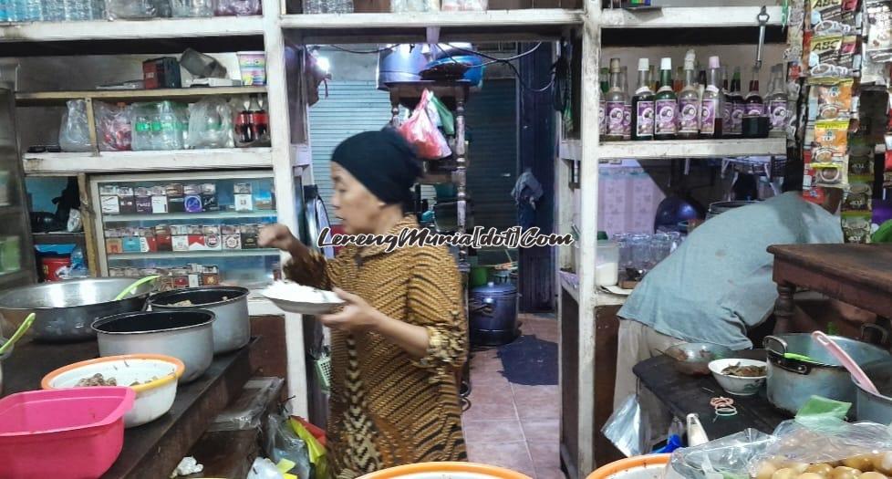 Rumini, generasi ke dua Warung Nasi "Ndembok" sedang melayani pembeli