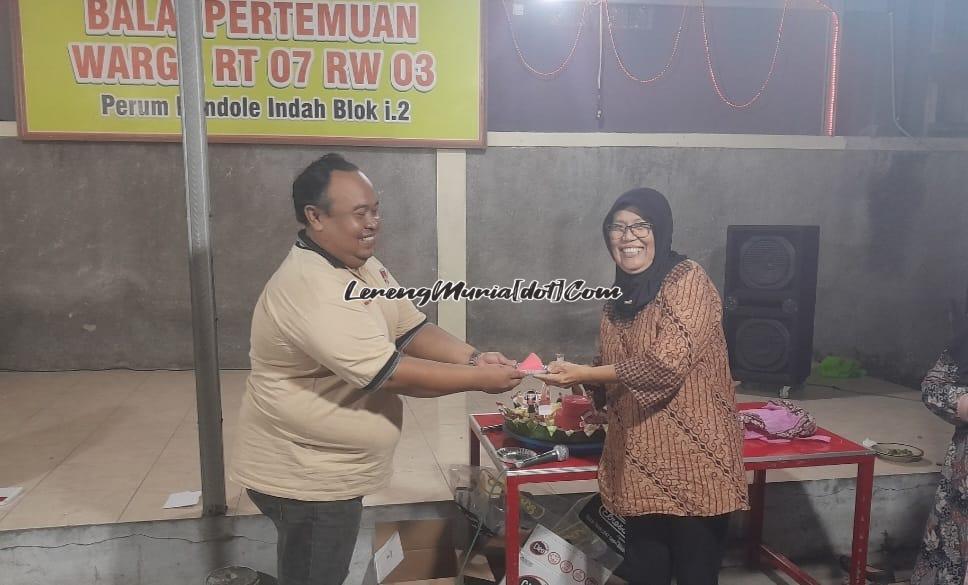 Sugiri selaku Kerua RT 7 RW 3 (kiri) menyerahkan potongan tumpeng untuk Mbah Ci (kanan)