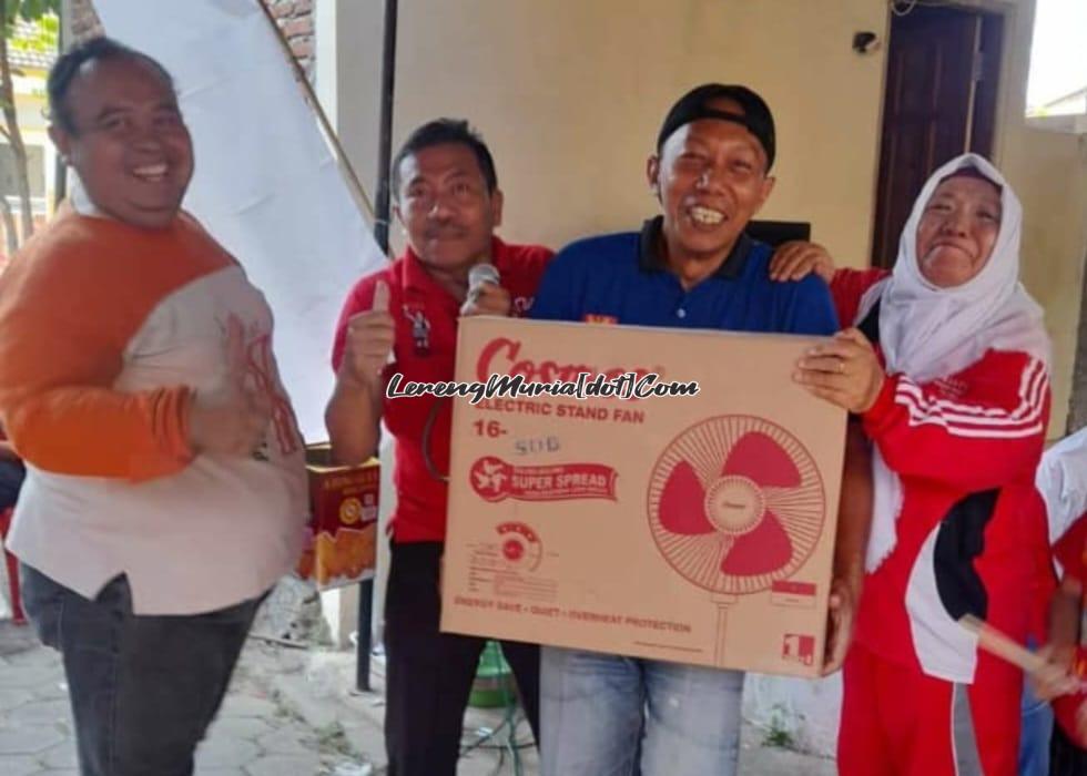 Sugiri (paling kiri) menyerahkan hadiah utama berupa kipas angin kepada salah satu warga yang mendapat door prize