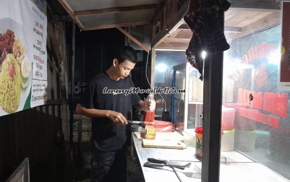 Mas Annur sedang mengiris roti bakar pesanan pelanggan