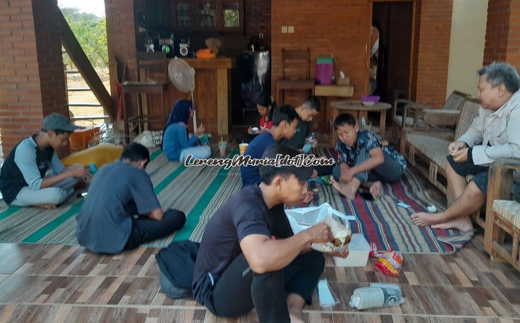 Pengunjung sedang menikmati hidangan yang dibawa dari rumah di bawah rumah panggung yang disediakan di kebun