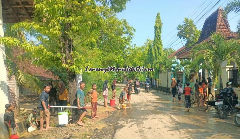 Jalan utama yang berlumpur akibat banjir bandang di Desa Angkatan Kidul Pati