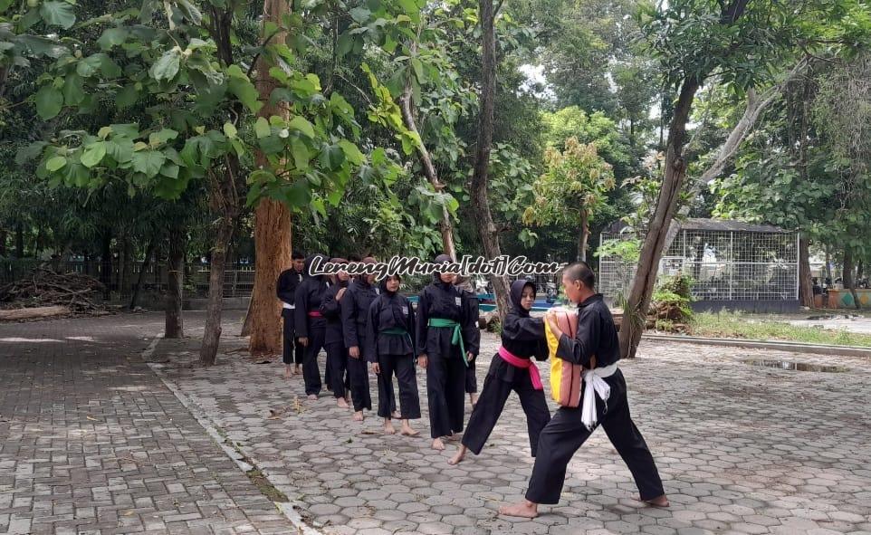 Pencak silat sedang berlatih pukulan dan tendangan di area parkir cadangan