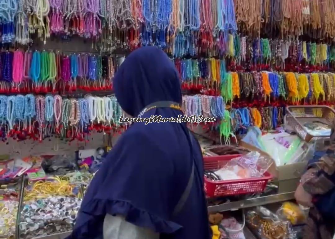 Pembeli sedang memperhatikan aneka tasbih di Toko "Serba 1 Real"