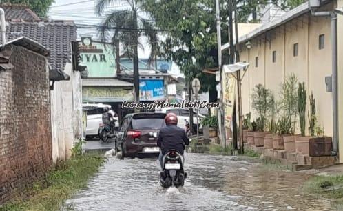 Pengendara sedang melintasi banjir di gang depan Pasar Puri Baru Kota Pati